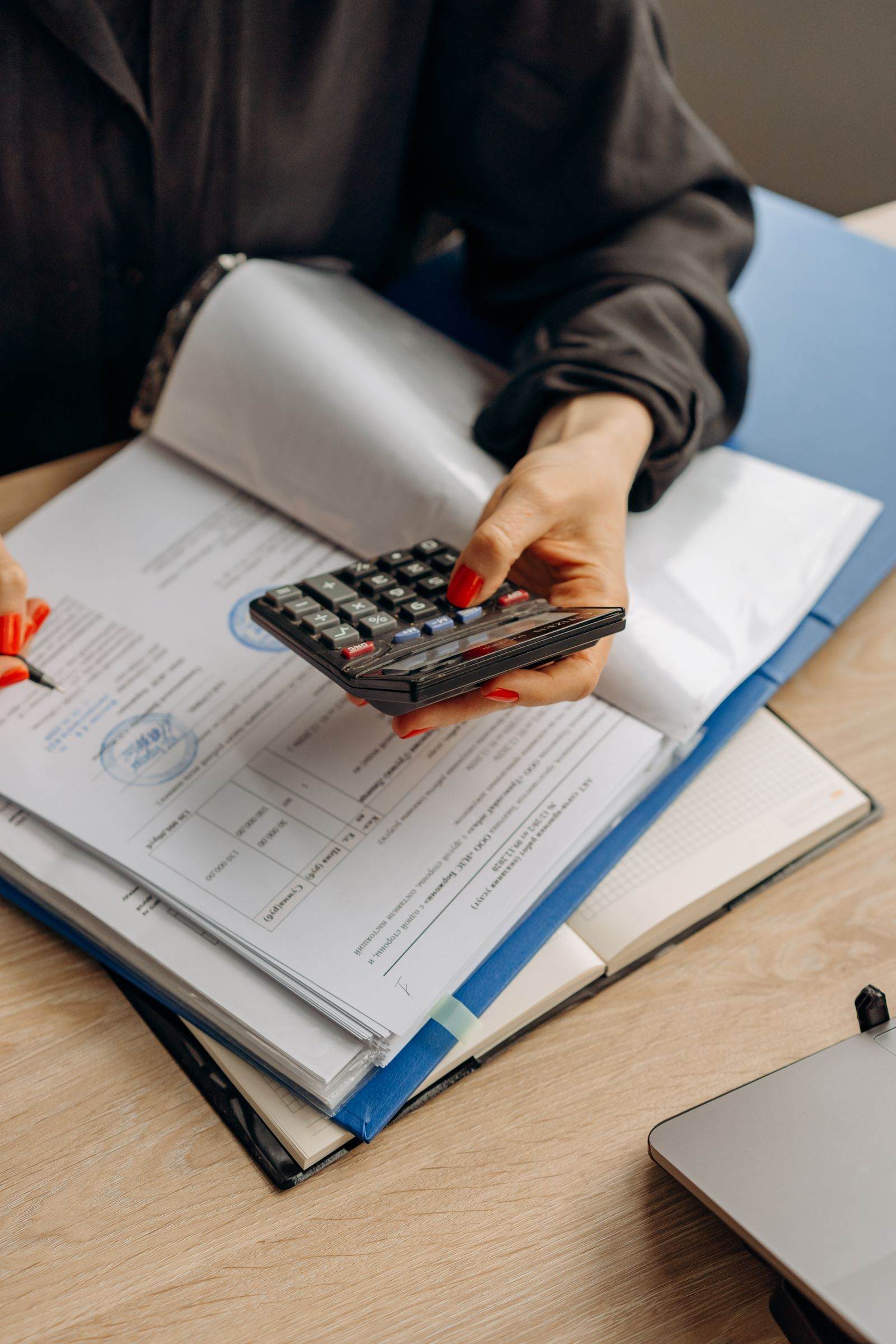 Accountant reviewing tax documents with a calculator in an office